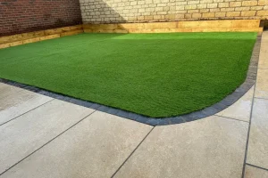 Easy to manage artificial grass surrounded by pathing.