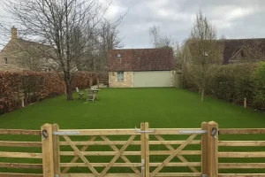 Outdoor annex house with a large luxury artificial grass lawn to look out at.
